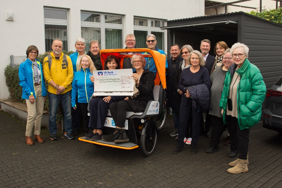 Gruppenbild mit Rikscha vor der neuen Garage im Hof der VR Bank in Bieber. Quelle: VR Bank Dreieich-Offenbach